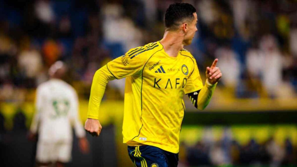Cristiano Ronaldo celebrating his first goal against Al Hazem in Al Nassr yellow jersey.